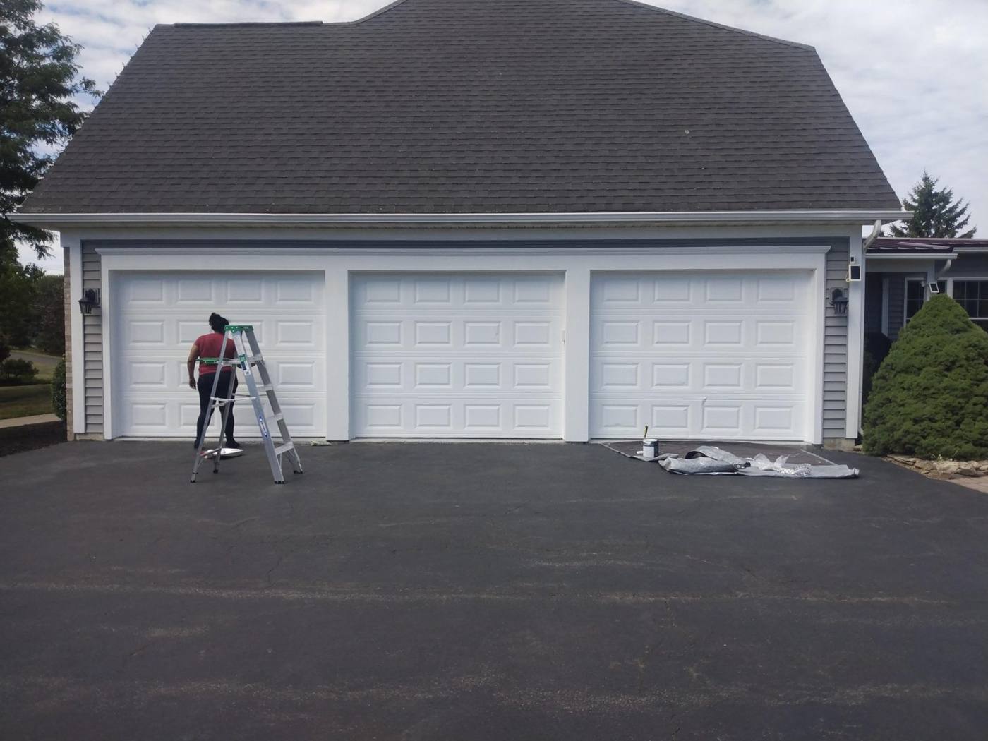 Victor on a ladder at a three-car garage