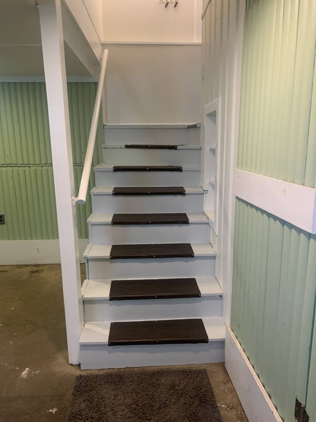 Stairs with green paneling and white risers